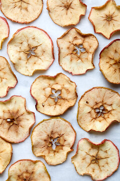 Overhead view of baked apple slices on white background