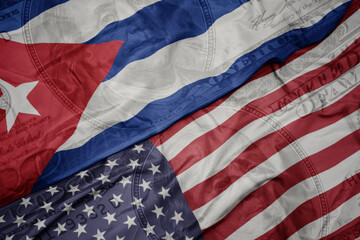 waving colorful flag of united states of america and national flag of cuba.