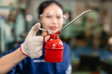 worker hand holding long neck oil lubricant can lube container for machine heavy industry workshop - 801368914