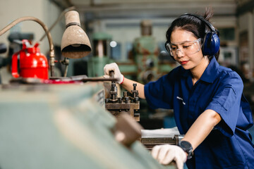 professional engineer worker with safety eyes protection focus working in metal lathe milling...