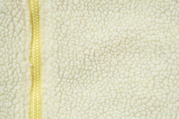Yellow zipper on wool plush fleece fur fabric texture background