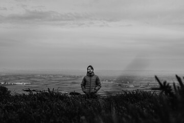 Man standing on hill, black and white