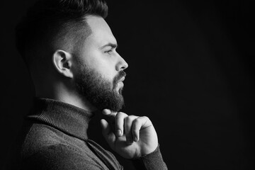 Portrait of handsome bearded man on dark background. Black and white effect