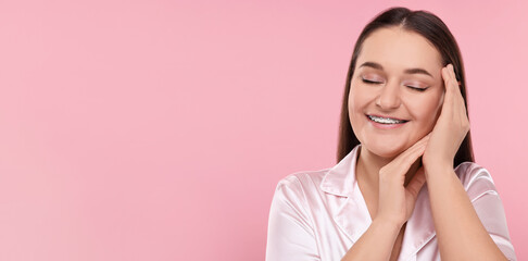 Smiling woman with braces on pink background. Banner design with space for text