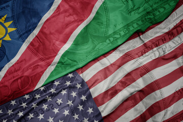 waving colorful flag of united states of america and national flag of namibia on the dollar money background. finance concept.