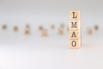 Word LMAO written on wooden cubes isolated on white background . Concept of laughing my ass off