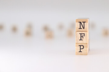 NFP acronym. Concept of Nonfarm Payrolls written on wooden cubes isolated on white background.
