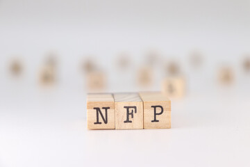 NFP acronym. Concept of Nonfarm Payrolls written on wooden cubes isolated on white background.
