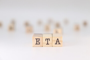 ETA acronym. Concept of estimated time of arrival written on wooden cubes isolated on white background.