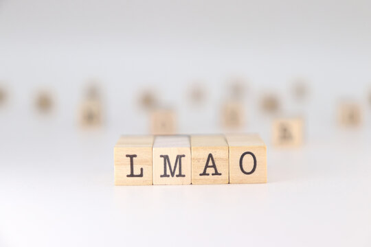 Word LMAO written on wooden cubes isolated on white background . Concept of laughing my ass off