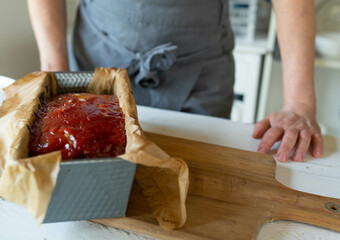 Uncut fresh cooked meatloaf with glaze in a baking pan