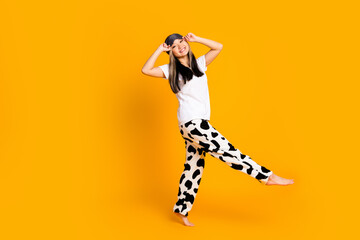 Full length photo of cheerful positive adorable woman wear white trendy pajama have fun isolated on yellow color background