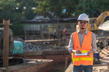Construction engineer working on a bridge construction site over a river,Civil engineer supervising work,Foreman inspects work at a construction site