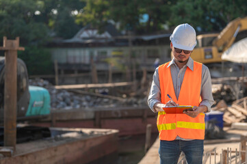 Construction engineer working on a bridge construction site over a river,Civil engineer supervising...