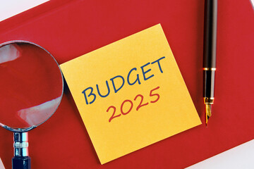 Business concept. The inscription BUDGET 2025 on a yellow sticker on a red business notebook in a...