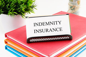 Business concept. INDEMNITY INSURANCE text written on the card on the stand