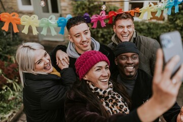 Diverse friends taking a group selfie at a Christmas party