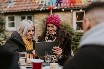 Friends looking at a tablet at a birthday party