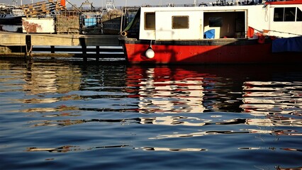 side reflection of boat on the harbor water