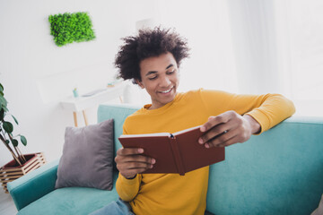Photo of nice young man read favorite book wear yellow pullover white interior apartment indoors