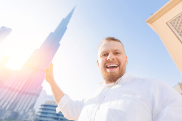 UAE tourism, selfie photo of happy young man tourist background skyscrapers in Dubai