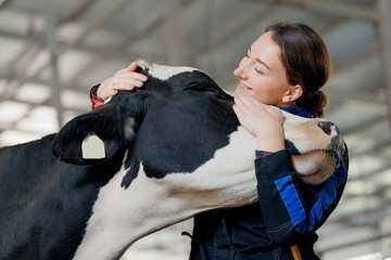 Happy young woman farm worker hugging cow as sign of concern for animal health care. Concept...