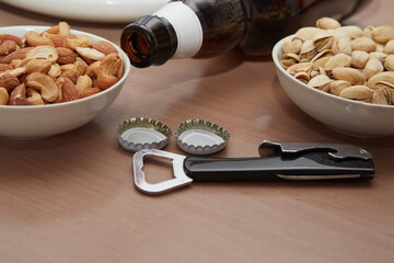 Bottle opener; bowls of nuts on the table close-up; beer snacks; atmosphere of a beer bar