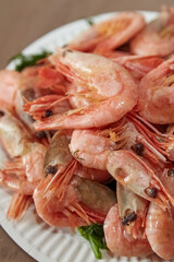 Boiled shrimps lie on a plate, seafood delicacies, shrimps on a plate, boiled shrimps, close-up, vertical shot