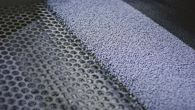 Granules undergo crucial stage in processing passing through mesh within specialized machine. Mesh used for maintaining quality and consistency ensuring meeting stringent standards