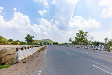 Landscape of Indian national highways surrounded by aravalli hills under the blue sky. National highways connected different cities and also saves time and fuel.