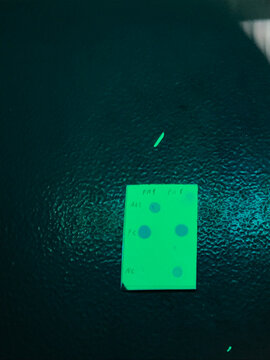 Fluorescent plate used in Thin-Layer Chromatography (TLC), with marked points indicating various substances. This method allows for precise separation and detection of chemical compounds