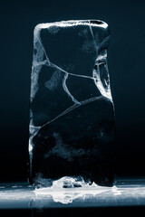 Crystal clear frosty textured natural ice block with cracks on black background.