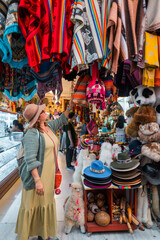 Naklejka premium Tourist looking at traditional Andean clothing. Concept of tourism