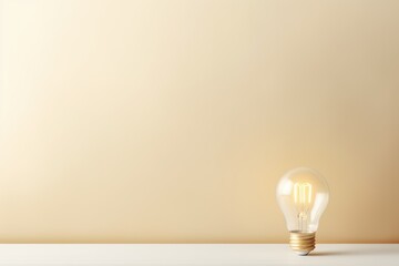 Beige backdrop with illuminated lightbulb on a white platform symbolizing ideas and creativity business concept creative thinking innovation new 