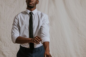 Businessman rolling shirt sleeve, black necktie