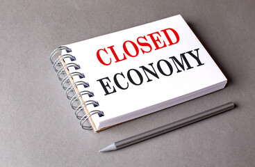 CLOSED ECONOMY text on notebook on grey background