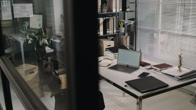 No people pan footage of empty barristers office with laptop, documents and Themis statue on table in modern law firm