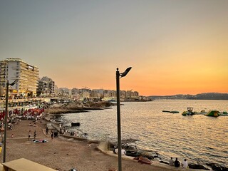 sunset over St Paul's Bay in Malta with a view of the seaside resort of Bugibba and its seaside on...