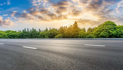 asphalt road and green forest with sky clouds at sunset