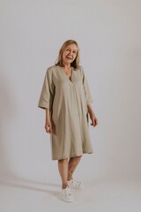 Fototapeta premium Mature woman wearing linen dress, minimal fashion