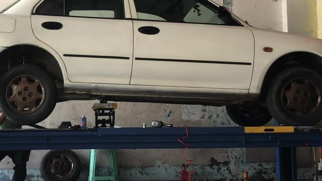 White car has been loaded onto the hydraulic lifter