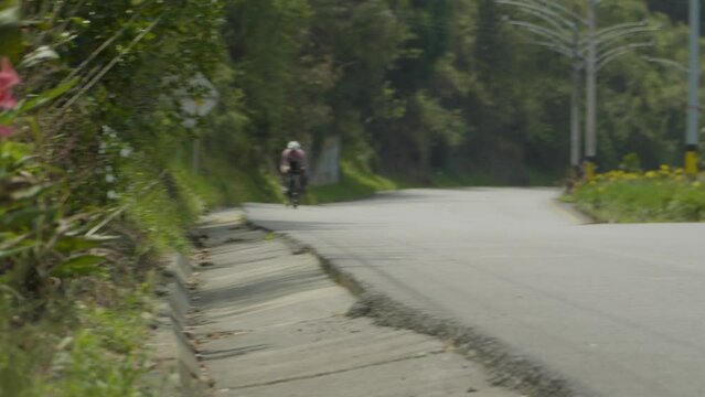 cyclist in pink jersey sprinting on a descent