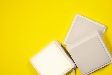 White led square led lamps on the yellow flat lay background with copy space.