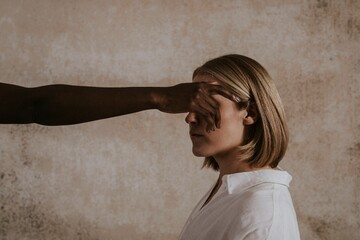 Fototapeta premium Woman's eyes covered by black woman's hand