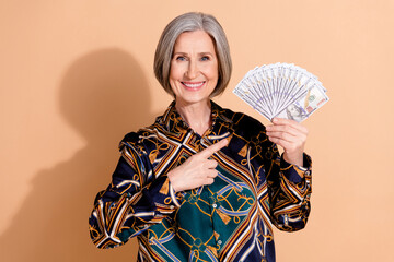Photo of satisfied positive retired person with bob hairdo wear print blouse indicating at dollars...