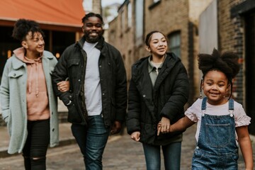 Obraz premium African-American family holding hands, walking in the city