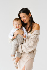 Happy young mother holding her little son in arms