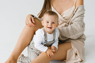 Baby boy on his mother's lap is smiling