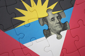 puzzle with the national flag of antigua and barbuda and usa dollar banknote. finance concept