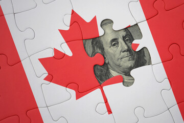 puzzle with the national flag of canada and usa dollar banknote. finance concept